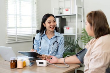 Bir hemşire, rutin sağlık kontrolü sırasında bir hastayla temas kurar, konforlu bir karşılama ortamında kişisel bakım ve konfor sağlar..