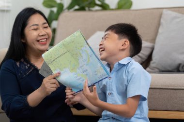 Anne ve oğul seyahat planlarını tartışırken keyifli bir anı paylaşıyorlar, bir haritaya bakıyorlar ve sonraki maceralarını hayal ediyorlar..