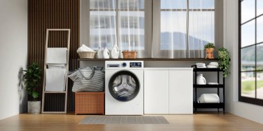 Güzel düzenlenmiş bir çamaşır odası modern çamaşır makineleri, dekoratif bitkiler ve şık depolama seçenekleri..