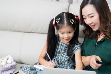 Bir anne kızının çevrimiçi öğrenimde yol göstermesine yardımcı olur. Eğitime hazırlanırken teknolojinin önemini vurgular..
