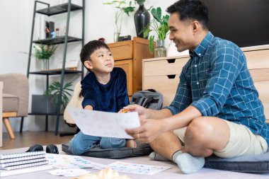 Bir baba ve oğul birlikte oturup, yeni öğrenim yılına hazırlanırken eğitimsel büyümeyi hızlandıran öğrenme faaliyetlerine odaklanırlar..