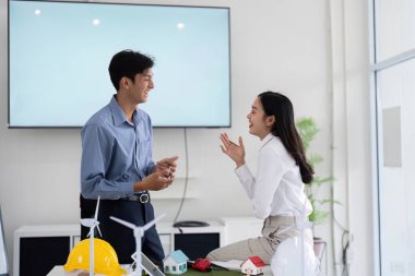 Mühendisler sürdürülebilirlik projeleri, fikirleri paylaşmak ve modern ofis ortamında işbirliği yapmak hakkında canlı bir tartışmaya girişirler..