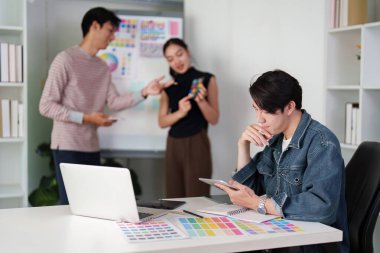 Grafik tasarım ekibi çeşitli renk paletleri ve planlarını inceleyerek yaratıcı iş akışlarını ve proje gelişimlerini geliştirir..