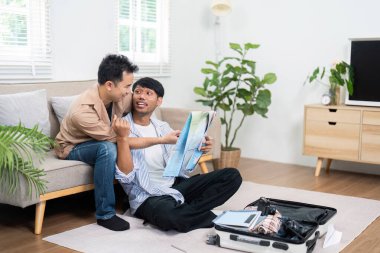 Bir LGBT çifti rahatça yerde oturup haritayı incelerken seyahat planlarını tartışıyor. Neşeli ifadeleri önlerindeki maceraya olan beklentilerini yansıtıyor..