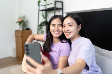 İki neşeli LGBTQIA arkadaşı evde neşeli bir selfie çekiyorlar, bağlantılarını ve müzik aşklarını gösteriyorlar..