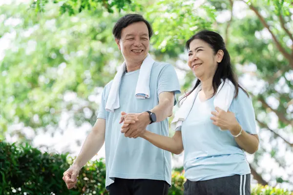 Üst düzey bir çift parkta el ele dolaşır, günlük yaşamlarında refahın ve arkadaşlığın önemini vurgular..