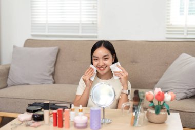 Bir kadın makyaj mendili tutarak ve gülümseyerek cilt bakımına hazırlanır. Görüntü, özgüvenin ve güzellik hazırlığının özünü yakalıyor..