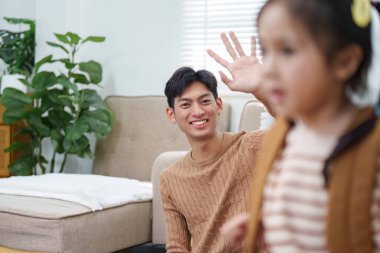 Neşeli bir baba kızına el sallayarak sıcak bir okula dönüş atmosferi yaratıyor..