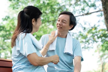 Üst düzey bir çift açık havada neşeli bir anı paylaşıyor, sosyal bağlantının ve sağlığın önemini vurguluyor..