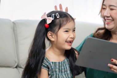 Bir anne ve kızı arasındaki neşeli etkileşim, birlikte eğitim faaliyetlerinden zevk aldıkları için okula dönüş hazırlıklarının heyecanını vurguluyor..