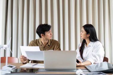 İki meslektaş sürdürülebilir uygulamalar, belgelerin gözden geçirilmesi ve yenilenebilir enerji hakkındaki fikirlerin paylaşımı hakkında bir sohbete girişiyor.