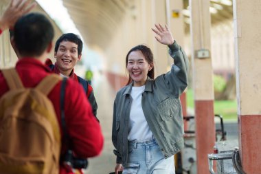 Arkadaşlar bir tren istasyonunda birbirlerine el sallayıp selamlaşıyorlar. Birleşmenin sıcaklığını ve heyecanını gösteriyorlar..