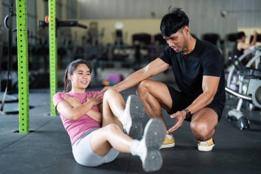 Genç bir çift spor salonunda vücut ve takım çalışmalarını geliştirmek için birlikte çekirdek egzersizleri yapıyor..
