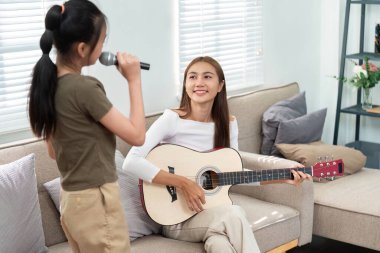 Bir anne, kızı şarkı söylerken gitar çalar. Oturma odasında eğlenceli ve müzikal bir bağ kurar..