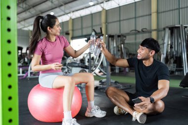 Bir kadın ve bir erkek vücut geliştirme egzersizinden sonra vücut geliştirme başarılarını kutluyor..