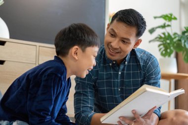 Bir baba oğluna kitap okur, sıcak ve davetkar bir ortamda okuma ve öğrenme aşkı yaratır..