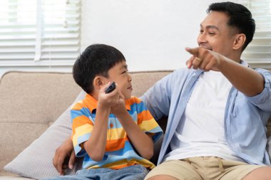 Bir baba ve oğul eğlenceli bir video oyunu seansının keyfini çıkarırlar, bağlantılarını gösterirler ve kahkahalarını paylaşırlar..