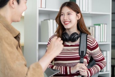 Tablet ve dizüstü bilgisayar kullanarak bir projede işbirliği yapan genç öğrenciler, takım çalışması ve akademik katılım sergiliyorlar.