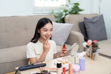 Bir kadın cilt bakımına ve makyaj rutinine odaklanır, aynanın önüne ruj sürer. Sahne, kendine bakmanın ve güzelliğin hazzını yakalar..