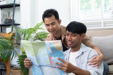 İki adam bir haritayı yakından inceliyor, potansiyel seyahat güzergahlarını ve varış noktalarını tartışıyor, ilerideki yolculuklarının heyecanını somutlaştırıyor..