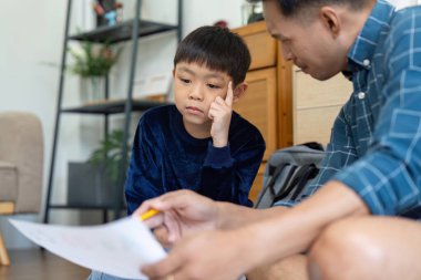 Bir baba ve oğul eğitim materyalleri üzerinde yoğunlaşır, merak uyandırır ve ev ortamında öğrenmeyi teşvik eder.
