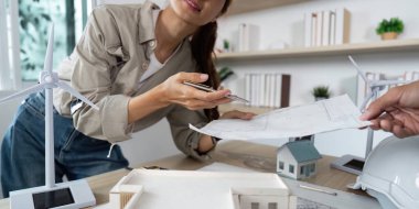 Bir kadın, mimari tasarımlar, sergilenen takım çalışması ve yenilikçi fikirler hakkında ortak bir tartışmaya girer..