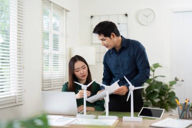 İki profesyonel, yenilenebilir enerji modelleri hakkında bir istişarede bulunarak, tartışmalarında sürdürülebilirliği vurguluyor.