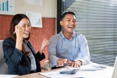 Parlak bir ofis ortamında başarılı bir projeyi neşeyle kutlayan iki profesyonel takım çalışması ve işbirliği sergiliyor..