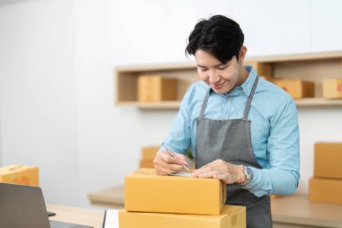 Adanmış bir girişimci teslimat için paketleri etiketler, şık bir ofis ortamında bağlılık ve detaya dikkat gösterir.