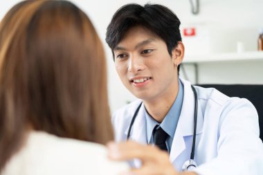 Bir doktor hastasına sıcak bir şekilde gülümser ve onunla iletişim kurar. Sağlık hizmetlerinde empati ve bakım gösterir..