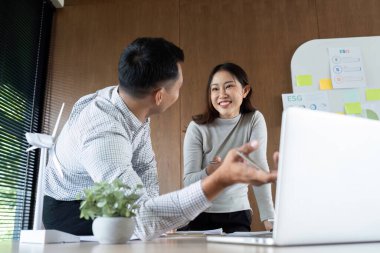 Bir kadın ve bir erkek, ESG stratejileri, takım çalışmasının altını çizmek ve kurumsal bir ortamda olumlu etkileşim hakkında neşeli bir konuşma yapıyorlar..