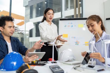 Çeşitli bir ekip, sürdürülebilir uygulamaları ve ESG girişimlerini görsel yardımlarla tartışan verimli bir toplantıya katıldı.