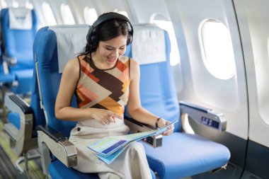 Neşeli bir kadın yolcu, yaklaşan seyahat maceraları için heyecanını gösteren bir harita üzerinde çalışıyor..