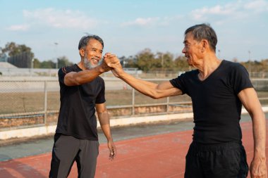 İki son sınıf öğrencisi antrenmandan sonra yumruk tokuşturuyor. Arkadaşlığın ve birlikte aktif olmanın zevkini vurguluyorlar..