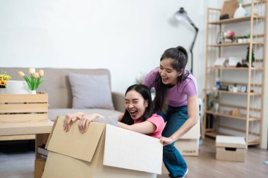 Karton kutularda oynayan neşeli bir çift yeni yaşam alanlarını ve birlikte yaşamanın neşesini kutluyor..