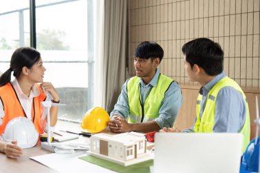 Bir mühendis ekibi, sürdürülebilirlik üzerine yoğunlaşan yenilenebilir enerji stratejileri hakkında ayrıntılı bir tartışmaya girişiyor..