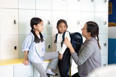 İki genç kız okul dolaplarıyla mutlu bir şekilde iletişim kuruyor. Yeni okul yılı için dostluk ve heyecan sergiliyorlar..