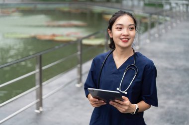 Tabletli ve gülümsemeli bir doktor, su özelliğinin yanında duruyor, sağlık ve teknoloji entegrasyonunu destekliyor..