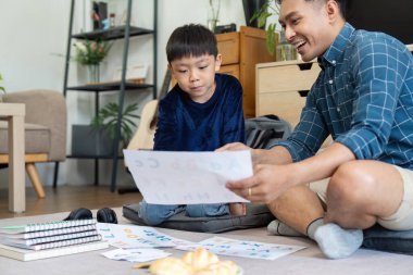 Bir baba ve oğul eğitim faaliyetleri üzerinde çalışır, harfleri ve sayıları araştırır, eğlenceli etkileşimler yoluyla öğrenmeyi geliştirir..