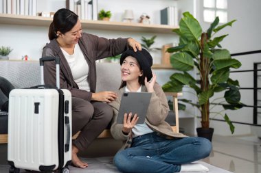 İki genç kadın heyecanlı bir şekilde eve dönüş yolculuklarını planlıyorlar, bir tablet kullanıyorlar ve etrafları seyahat gereksinimleriyle çevrili, dostluk ve macera sergiliyorlar..