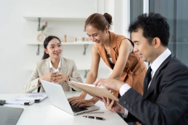 Çeşitli profesyonellerden oluşan bir grup, parlak bir ofis ortamında fikirlerini ve stratejilerini tartışmak üzere ortak bir toplantıya katılıyor..