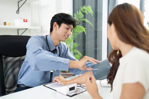 Врач измеряет кровяное давление пациентов, проявляя практическую помощь и внимание в клинической обстановке.