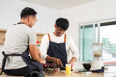 Modern bir mutfakta taze bir yemek hazırlarken iki arkadaş kahkahalarını paylaşıyor. Arkadaşlığa, aşçılığa ve sağlıklı yaşam tarzına vurgu yapılıyor..