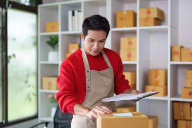 Girişimci teslimat detaylarını incelerken paketleri düzenler, küçük işletmelerde etkin lojistikleri gösterir.