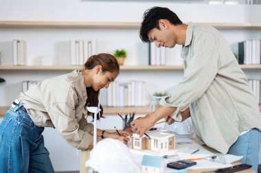 İki mimar sürdürülebilir bir yapı modeli, takım çalışması ve tasarımda yaratıcılık üzerine işbirliği yaparlar..