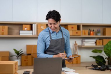 Çevrimiçi siparişleri yönetirken not alan genç bir girişimci, e-ticaretteki organizasyonun önemini vurguladı.