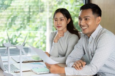 İki profesyonel, çalışmalarında yenilik ve çevre sorumluluğunu vurgulayarak sürdürülebilir proje planları hakkında bir tartışmaya giriştiler.