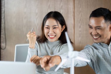 İki meslektaş, ekolojik bilinçli bir çalışma alanında sürdürülebilir projeleri tartışırken sevinç ve coşkuyu dile getiriyor.