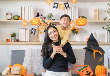 Bir anne ve oğlu Cadılar Bayramı 'nı birlikte kutluyor. Etrafı şenlikli süslemeler ve şakacı balkabaklarıyla çevrili..