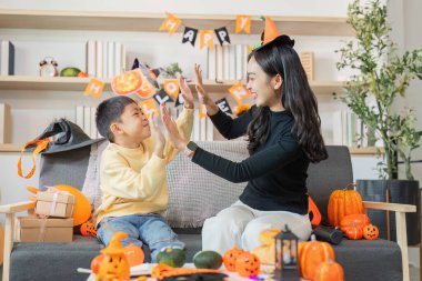 Bir anne ve oğlu, Cadılar Bayramı dekoru ile çevrili eğlenceli bir oyun oynar ve aile bağlarının ruhunu yakalar..